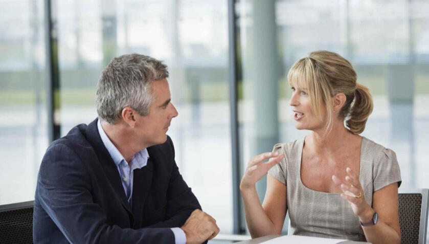 Advisor and executive in a confidential one-to-one meeting discussing critical business decisions.